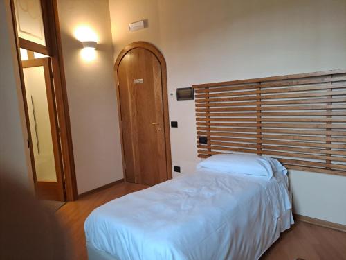 a bedroom with a bed and a wooden door at Agriturismo Cascina Farisengo in Stagno Lombardo
