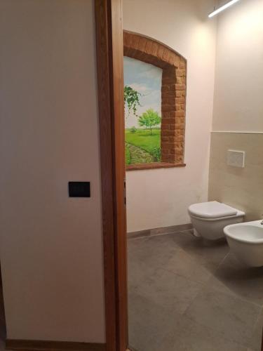 a bathroom with a toilet and a sink and a window at Agriturismo Cascina Farisengo in Stagno Lombardo