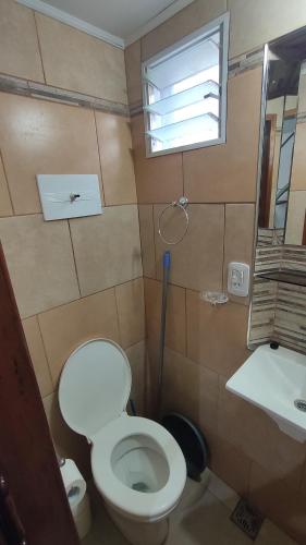 a bathroom with a toilet and a sink and a window at Alquiler temporario Olavarría in Olavarría