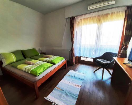 a living room with a green couch and a window at Szt Kristóf Bed and Breakfast in Győr