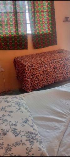 Tongwe Cultural Heritage Center في Katumbi: سرير في غرفة مع طاولة ونوافذ