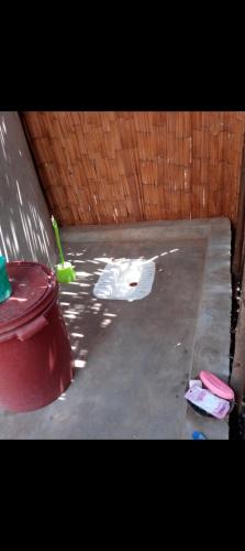 Tongwe Cultural Heritage Center في Katumbi: كراج به سلة مهملات حمراء وسياج