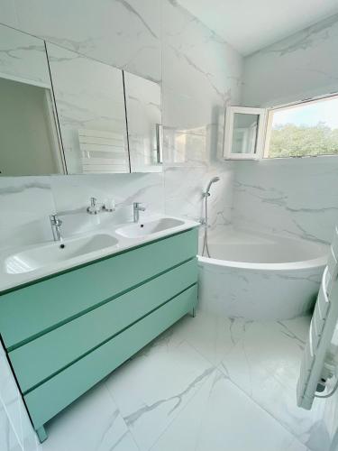 La salle de bains blanche est pourvue d'une baignoire, d'un lavabo et d'une baignoire. dans l'établissement Haut de Villa - Proche plages, Piscine privée, à Saint-Raphaël