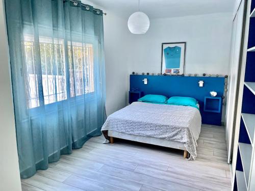une chambre avec un lit bleu et une fenêtre dans l'établissement Haut de Villa - Proche plages, Piscine privée, à Saint-Raphaël