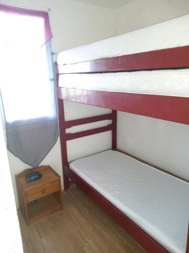 deux lits superposés dans une chambre avec fenêtre dans l'établissement Appartement avec piscines, à Canet