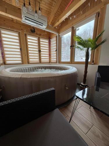 a large tub in a room with a tree in it at Vila Presjenica in Bunovci