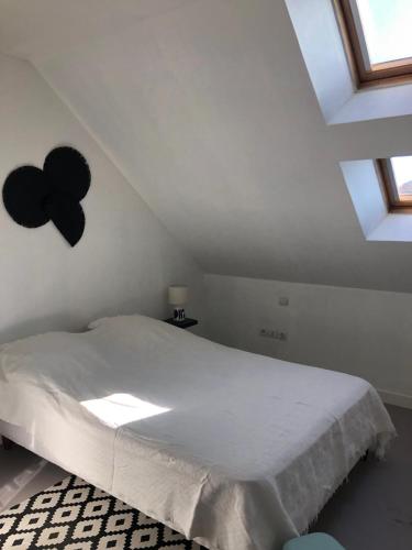 une chambre avec un grand lit blanc dans un grenier dans l'établissement Le Voyageur ZEN, à Berck-sur-Mer