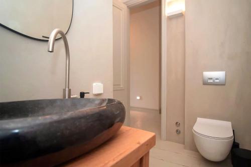 a bathroom with a sink and a toilet at Samos Serenity - Classic Retreat near the beach in Koumeika