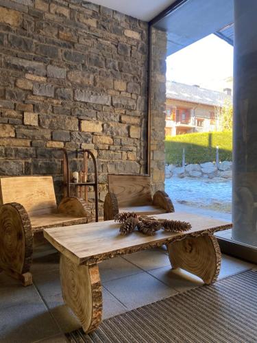 a wooden table and bench with pine cones on it at Aparthotel Siente Boí & SPA in Pla de l'Ermita