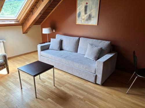 a living room with a couch and a table at Aparthotel Siente Boí & SPA in Pla de l'Ermita
