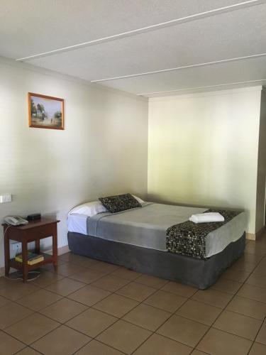 莫兰巴黑色方块汽车旅馆的一间卧室，里面有一张大床和一张桌子。