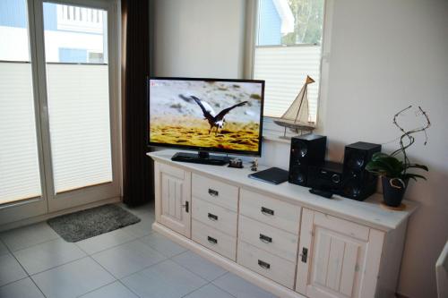 einen Flachbild-TV auf einer Kommode in der Unterkunft Boddenblick - Breege in Breege