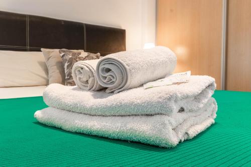 a pile of towels sitting on top of a bed at Apartments Babel Recoleta in Buenos Aires