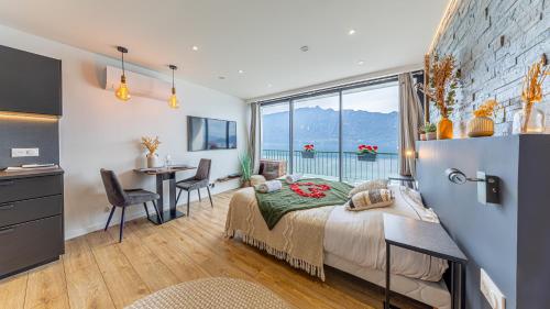 a bedroom with a bed and a table and a window at L'Edelweiss du Lac in Tresserves