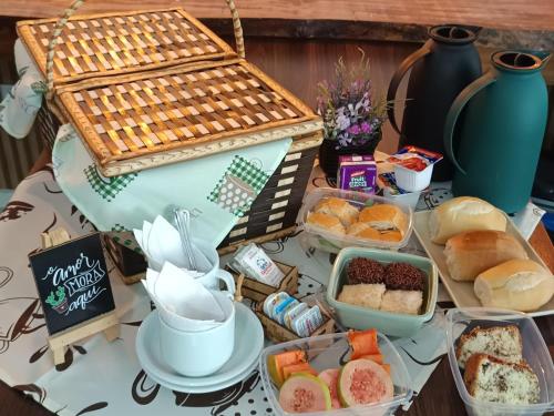 a table topped with a buffet of bread and pastries at Pousada Suítes 590 in Penha