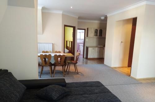 a living room with a dining room table and chairs at Apartmány ORAVA-EDDA in Trenčianske Teplice