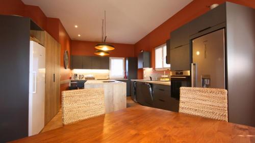 a large kitchen with a wooden table and chairs at Villa avec Vue Panoramique et Piscine in Dieulefit
