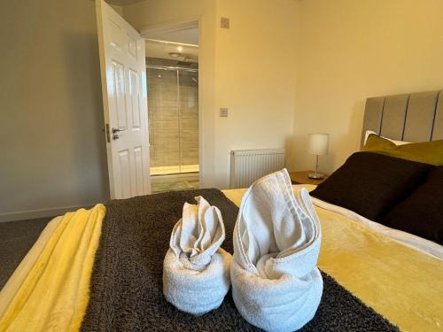 a bedroom with a bed with towels on it at 5 Town centre, entire flat, free parking king bed in Huntingdon