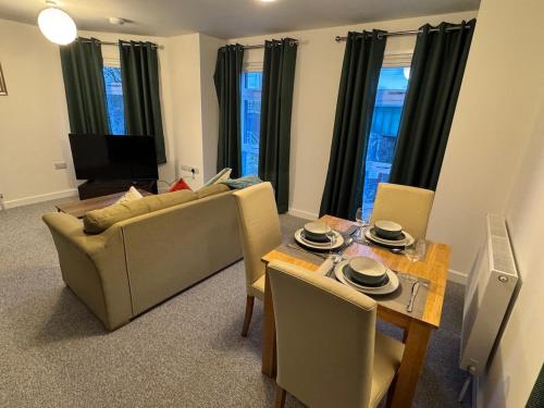 a living room with a couch and a table with chairs at 5 Town centre, entire flat, free parking king bed in Huntingdon