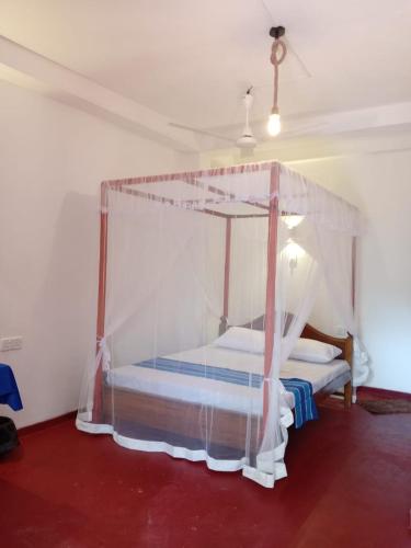 a bedroom with a canopy bed in a room at River bend surf lodge in Weligama