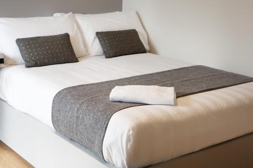 a large white bed with two pillows on it at Dotcampus Roma City Center in Rome