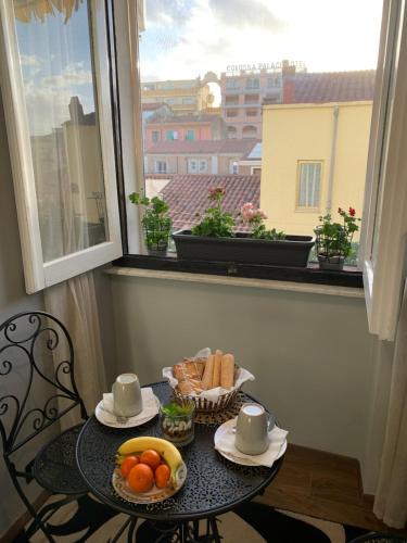 - une table avec une corbeille de pain et de fruits sur une fenêtre dans l'établissement B&B Tanda Rooms Olbia, à Olbia