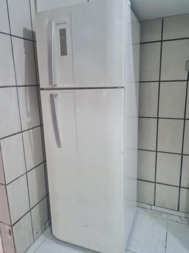 a white refrigerator in a corner of a kitchen at Casa de praia 5 km de Olinda PE in Paulista