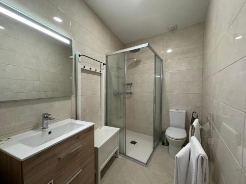 a bathroom with a sink and a shower and a toilet at Casinhas Dom Afonso by Hotel Dom Afonso in Monção
