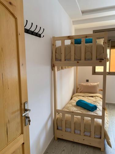 a bedroom with a bunk bed and a door at Nomad Surf Lodge in Imsouane