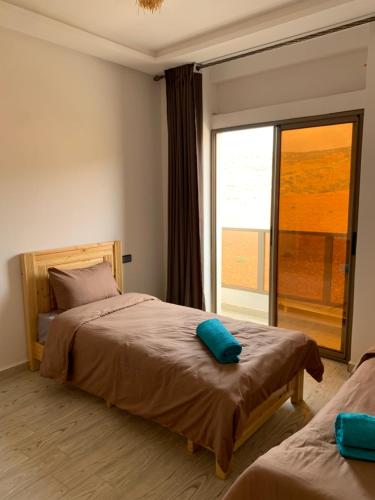 a bedroom with two beds and a large window at Nomad Surf Lodge in Imsouane