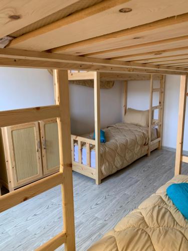 two bunk beds in a room with wooden ceilings at Nomad Surf Lodge in Imsouane