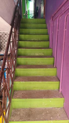 a set of stairs in a building with green at Linga HomeStay in Kanchipuram