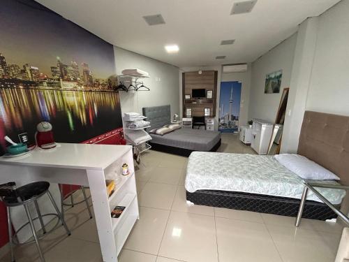 a room with a bed and a desk in it at Loft confortável com Self Cheking in Joinville
