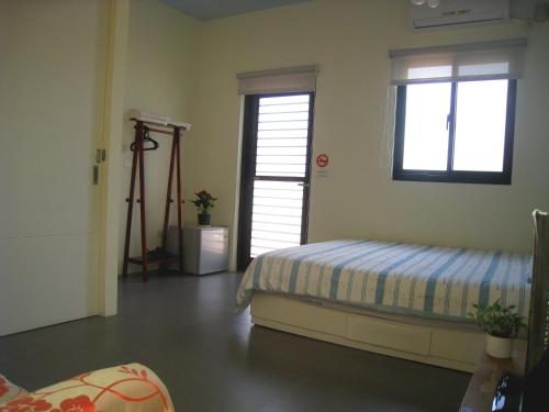 a bedroom with a bed and a window and a tripod at Penghu 123 V-Stone in Magong