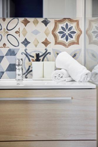 une salle de bain avec un lavabo et des serviettes sur un comptoir dans l'établissement ღ IntotheWild - Commodités, Parking & Wifi Fibre, à Sautron