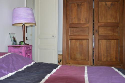 - une chambre avec un lit et une porte en bois dans l'établissement Appartement village Jourdain, à Paris