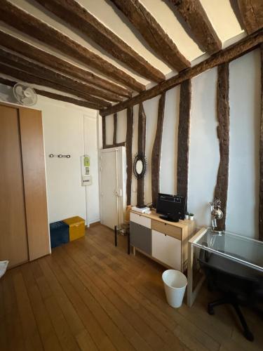Cette chambre dispose d'un bureau et d'une horloge murale. dans l'établissement Studio cosy au cœur de Paris, à Paris