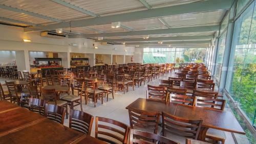 a room filled with wooden tables and chairs at Eldorado Atibaia Eco Resort in Atibaia