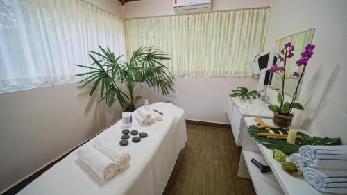 a bathroom with two tables with towels and plants at Eldorado Atibaia Eco Resort in Atibaia