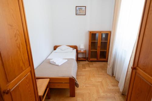 a small bedroom with a bed and a wooden floor at Pokoje Gościnne Dom św. Szymona in Kraków