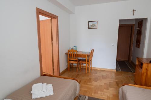 a room with a bed and a table with a chair at Pokoje Gościnne Dom św. Szymona in Kraków