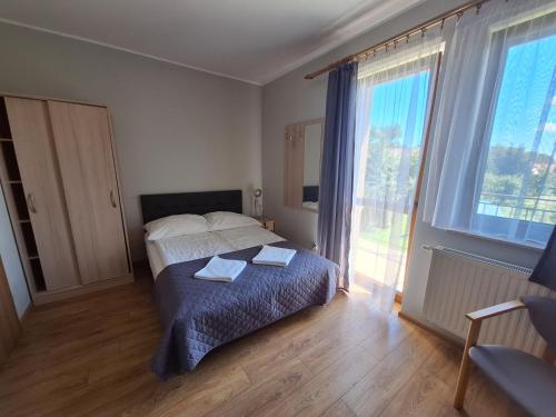 a bedroom with a bed with two towels on it at Willa Maczek in Sztutowo