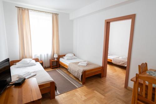 a small room with two beds and a mirror at Pokoje Gościnne Dom św. Szymona in Kraków
