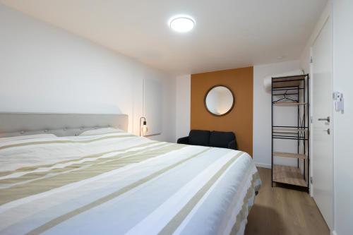 a bedroom with a large white bed and a mirror at La Rocha in La Roche-en-Ardenne