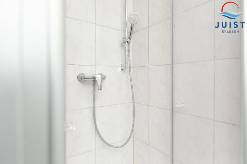 een douche met een douchekop in een badkamer bij Töwerland Zimmer 2 in Juist