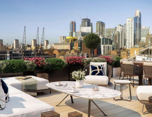 a patio with tables and chairs and a city skyline at Luxury Apartments near Canary Wharf in London