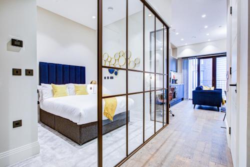 a bedroom with a bed and a glass wall at Luxury Apartments near Canary Wharf in London