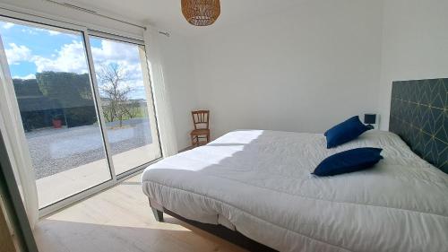 a bedroom with a large bed and a large window at Maison tout confort proche Azay-le-Rideau 8 p in Azay-le-Rideau