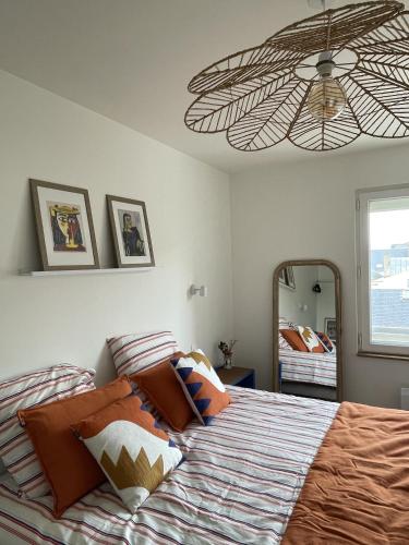 une chambre avec un lit et un grand miroir dans l'établissement Appartement 2 etoiles haut de gamme Le Pompidou, à Les Sables-dʼOlonne