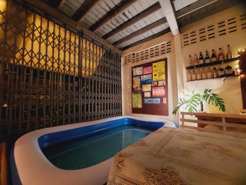 eine Badewanne in einem Raum mit einem Tisch in der Unterkunft HostelBed and Retreat Phitsanulok in Phitsanulok